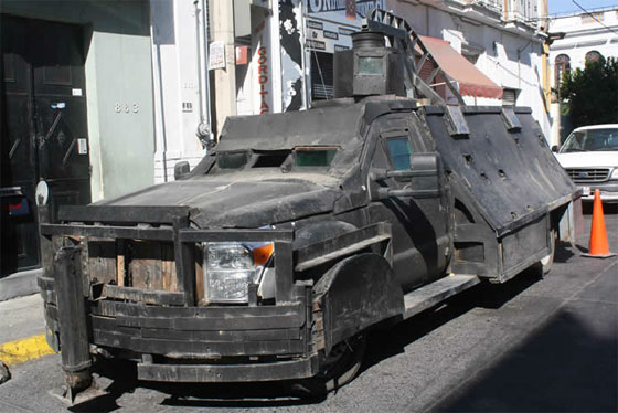 Photograph of an improvised armored pickup with an enclosed steel body and roof turret